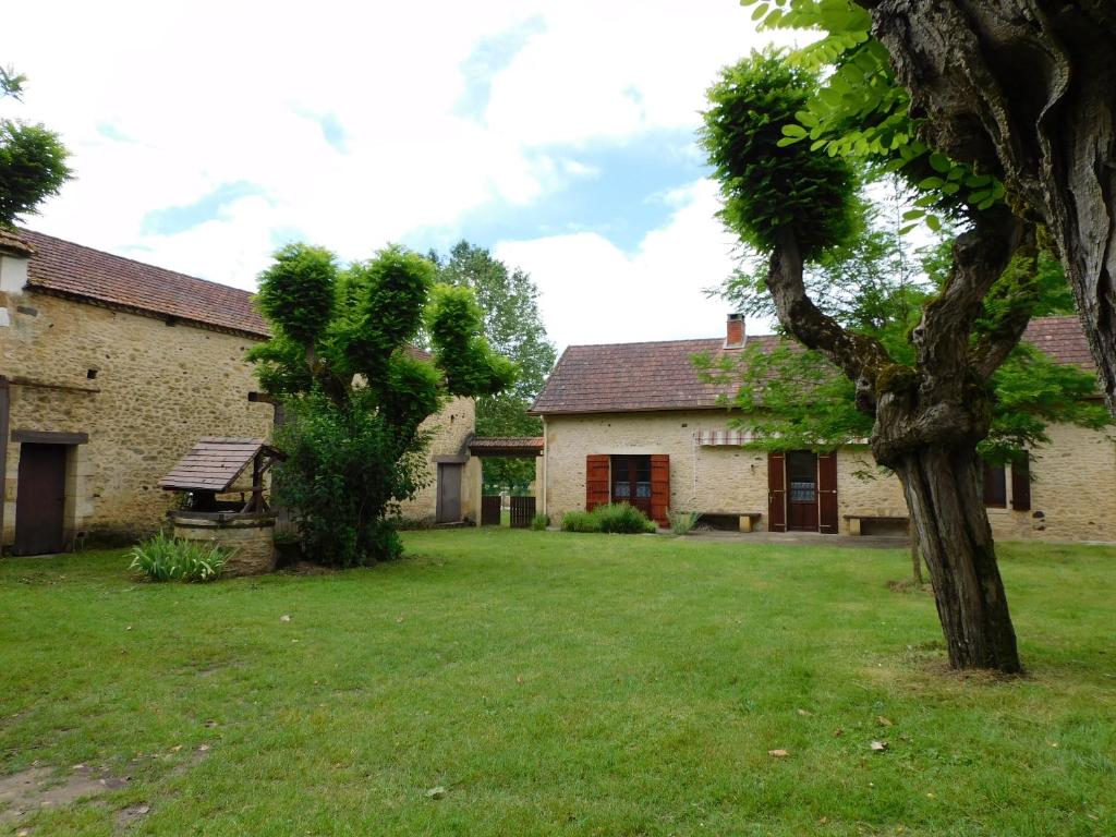 une maison dotée d'une cour verdoyante avec un arbre dans l'établissement Les Salveyries en Dordogne Maison de campagne avec piscine et grands espaces, à Allès-sur-Dordogne