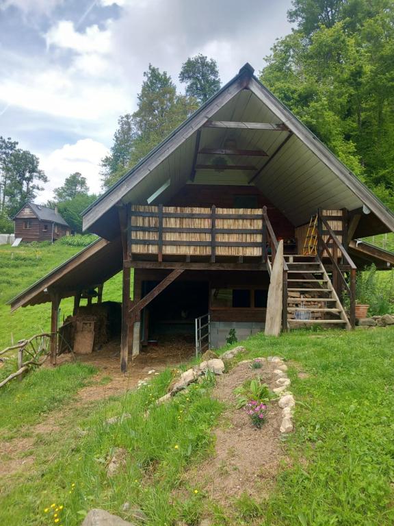 a large building with a gambrel roof with a porch at Le chalet a la ferme in Massat