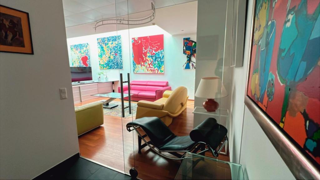 a living room with two chairs and a pink couch at Domus Hotel in Luxembourg