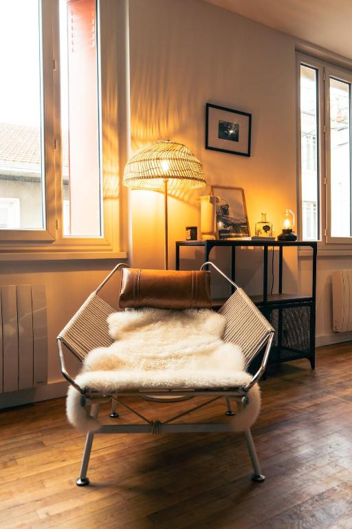 - un salon avec une chaise et une couverture dans l'établissement Le Lavoisier - Appartement spacieux - Esprit loft, à Clermont-Ferrand
