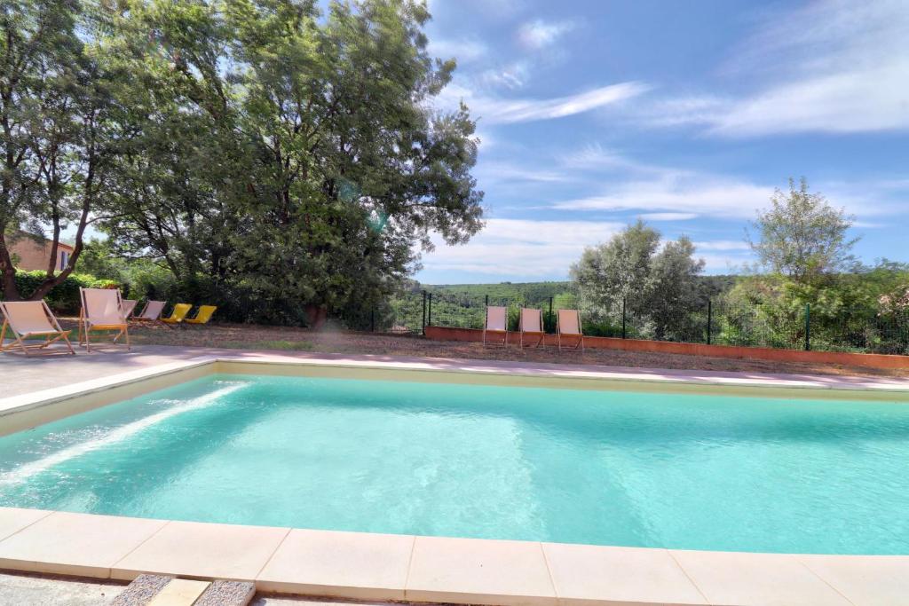 une grande piscine avec des chaises dans une cour dans l'établissement 4-guest flat with terrace & shared pool Verdon countryside, à Artignosc-sur-Verdon