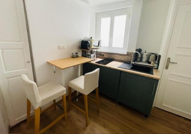 - une cuisine avec un comptoir, 2 chaises et un évier dans l'établissement Stade Mayol, à Toulon