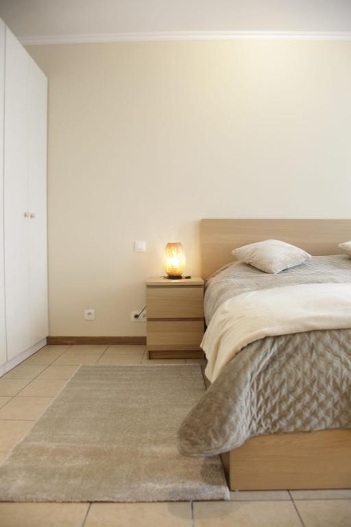 une chambre avec un lit et une table de chevet avec une lampe dans l'établissement Sunny Stay & Chill, à Bruxelles