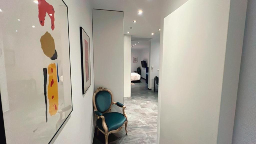 a hallway with a green chair in a room at Domus Hotel in Luxembourg