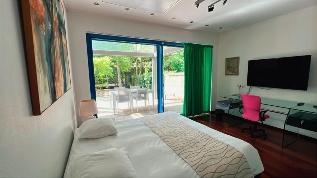 a bedroom with a bed and a desk and a television at Domus Hotel in Luxembourg