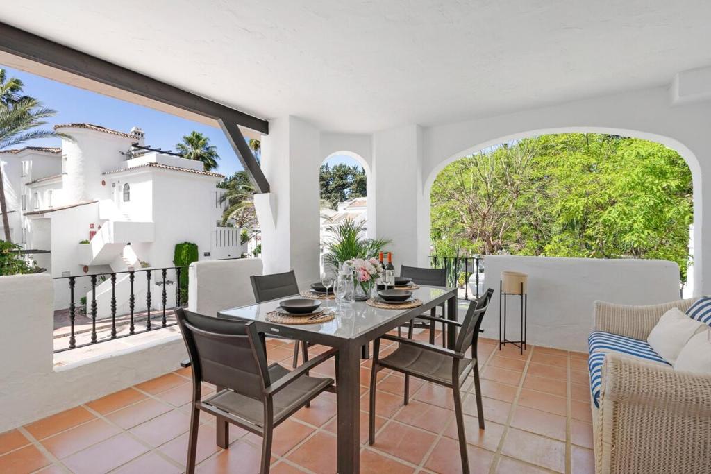a dining room with a table and chairs on a balcony at Nice Casa los Naranjos Marbella by Casa del Sol HR in Marbella