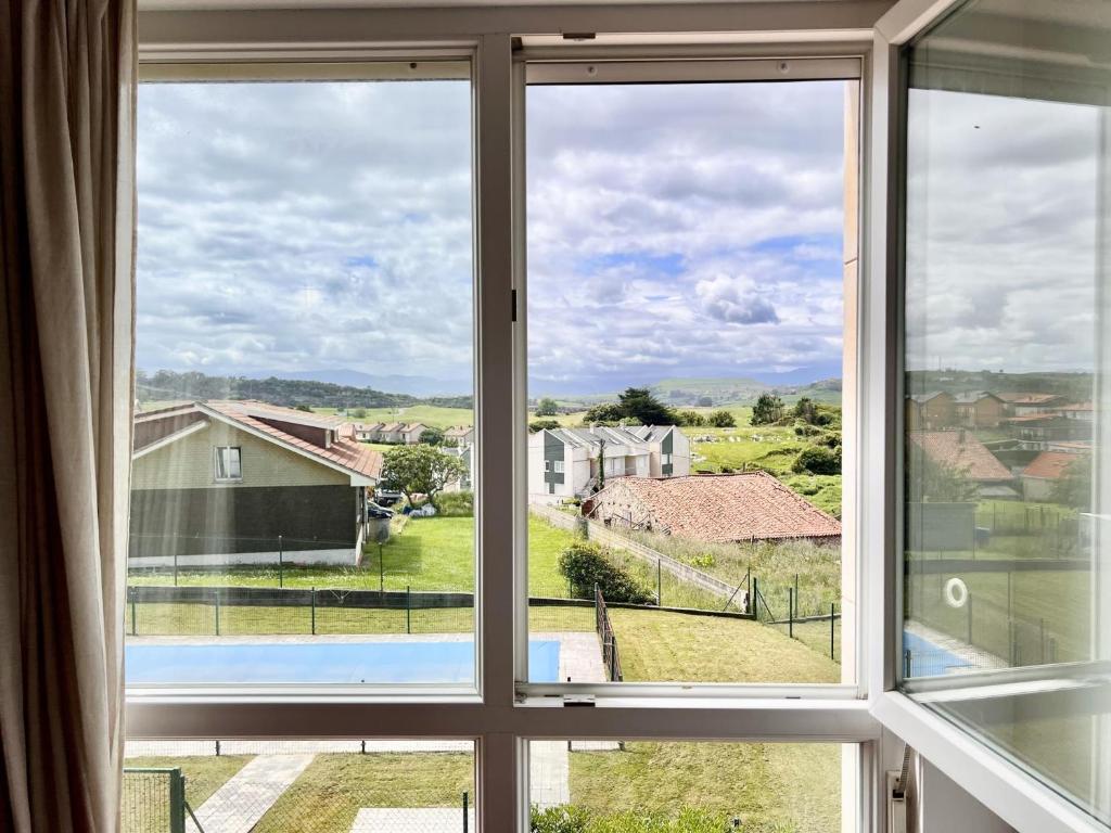 a window with a view of a house at Apartamento La Cala Cuchía - Monabri in Cuchia