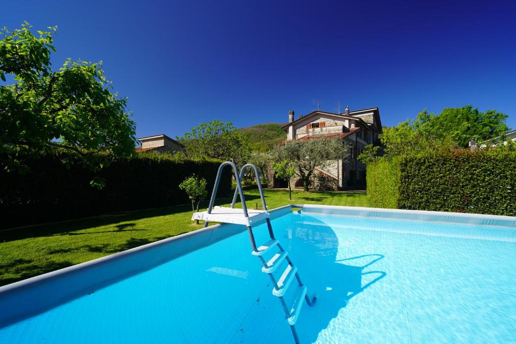 a swimming pool with a chair in a yard at Villa Delia 16p 2 Pools BBQ by VILLASRETREATS in Talavorno