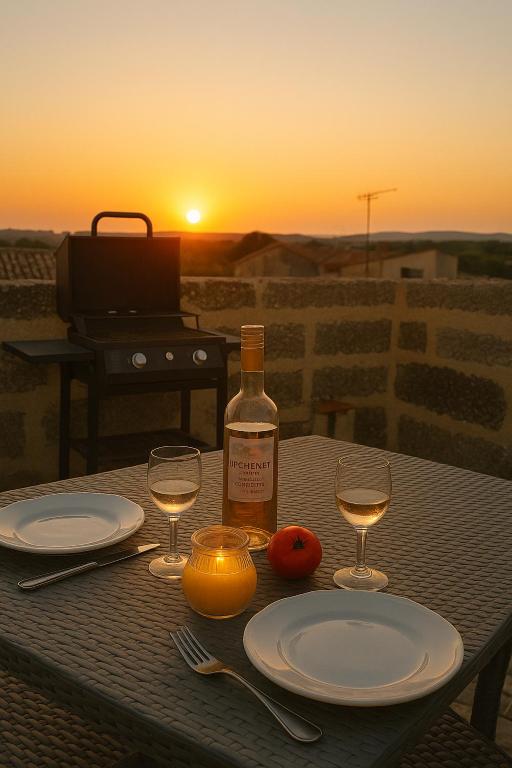- une table avec une bouteille de vin et deux verres dans l'établissement INSOLITE STUDIO -La Tour des Templiers-, à Montfrin