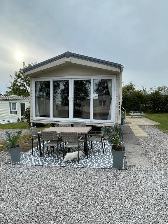 a house with a picnic table and a dog under it at Bowland Fell Retreat in Tosside
