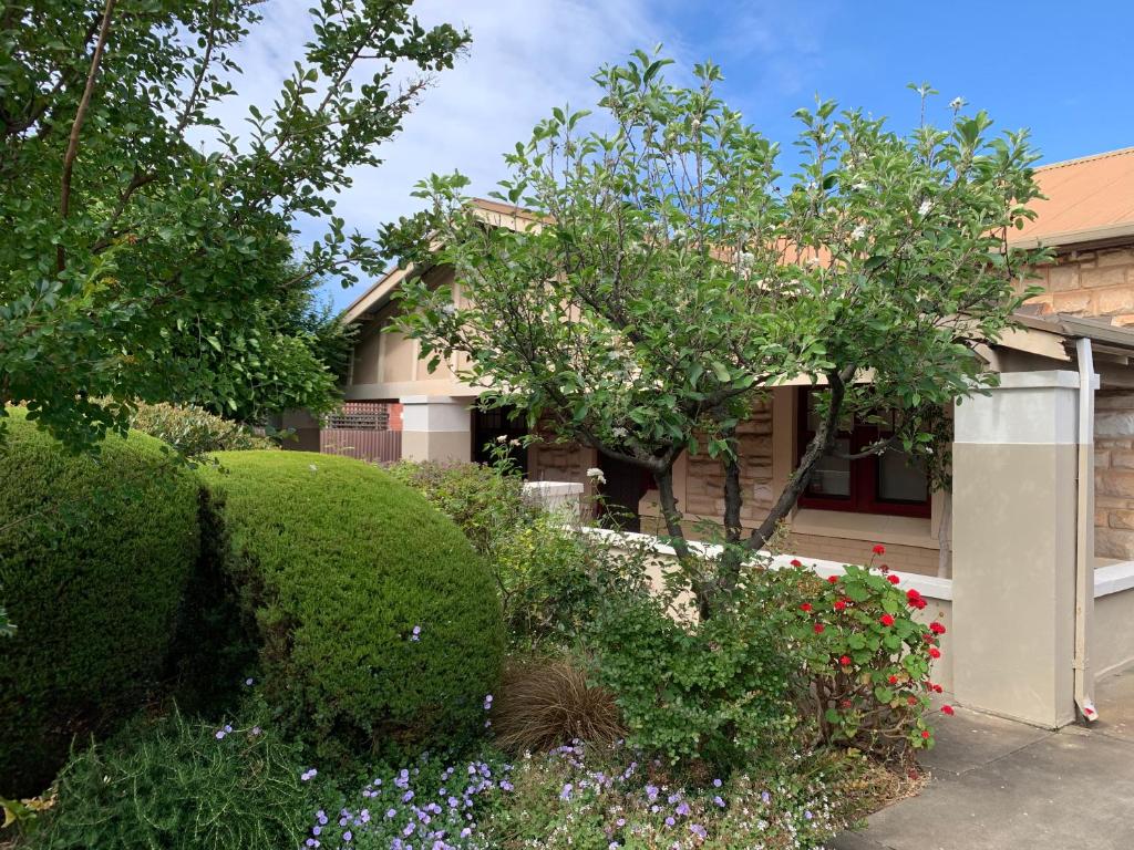 a house with bushes and flowers in front of it at Botanic Bliss Bungalow in Adelaide