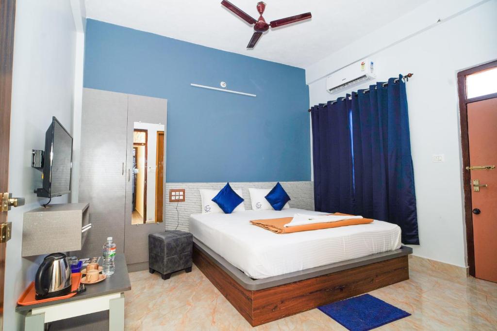 a bedroom with a bed and a blue wall at Golden IB'S Gokarna in Gokarna