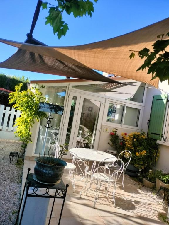 un patio avec une table et des chaises devant une maison dans l'établissement Mini gîte de 21 m carrés, à La Bouilladisse