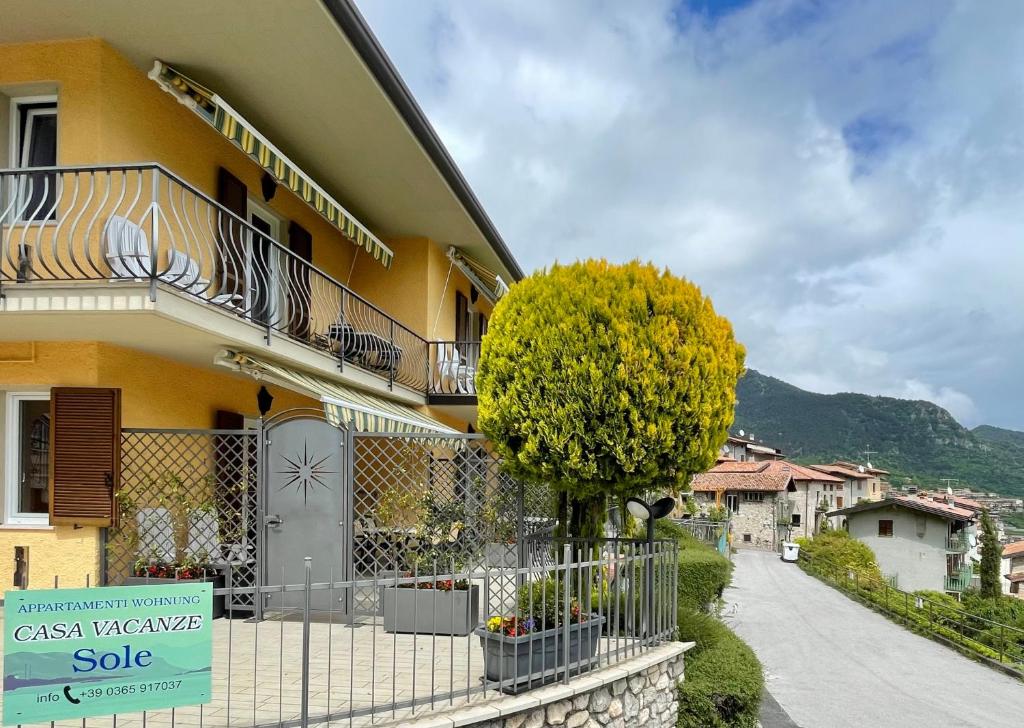 a yellow house with a sign in front of it at Casa Vacanze Sole in Tremosine Sul Garda