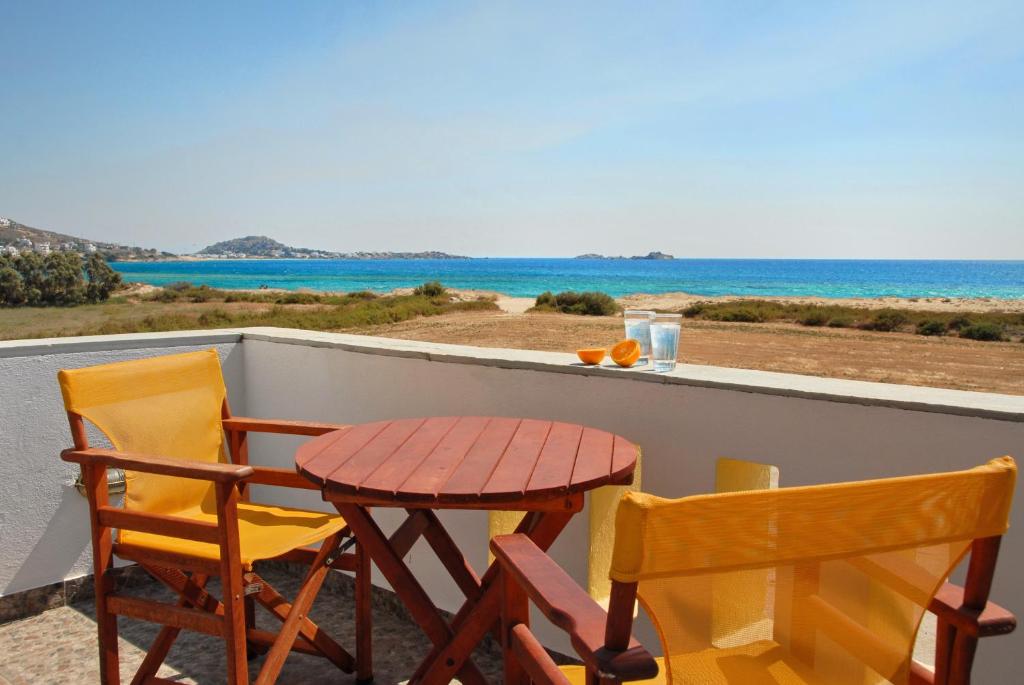 una mesa y 2 sillas en un balcón con vistas al océano en Sea Melody Studios, en Plaka