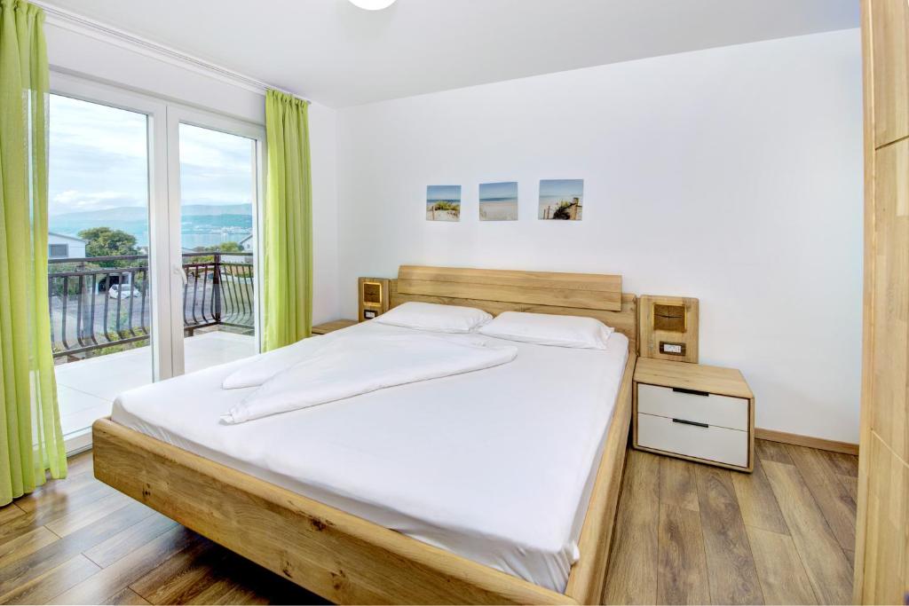 a bedroom with a bed and a large window at Cool Šilo Appartement Resort in Šilo