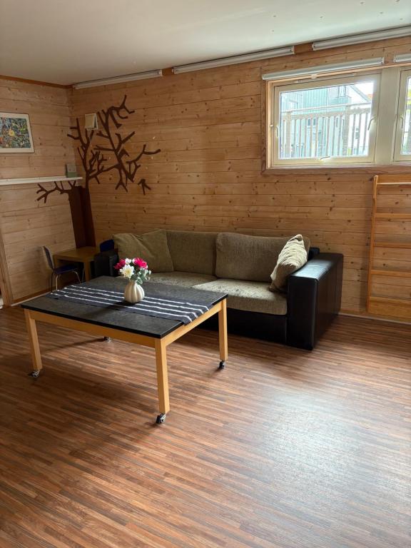 un salon avec un canapé et une table basse dans l'établissement Child friendly basement apartment, à Lii