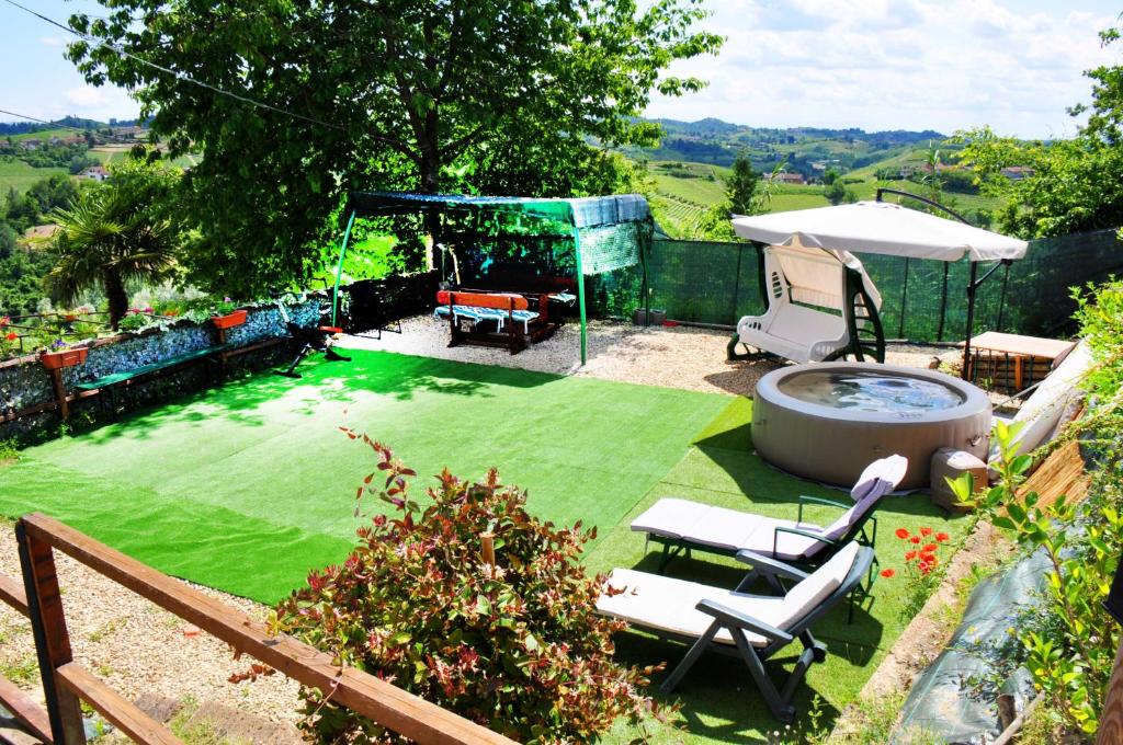 a garden with a pool and chairs and an umbrella at Il Casale Del Roero in Canale