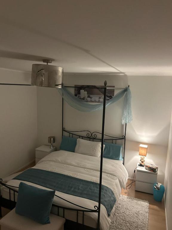 Un dormitorio con una cama con dosel y almohadas azules. en Chambre Zen Et Calme, en Bouveret