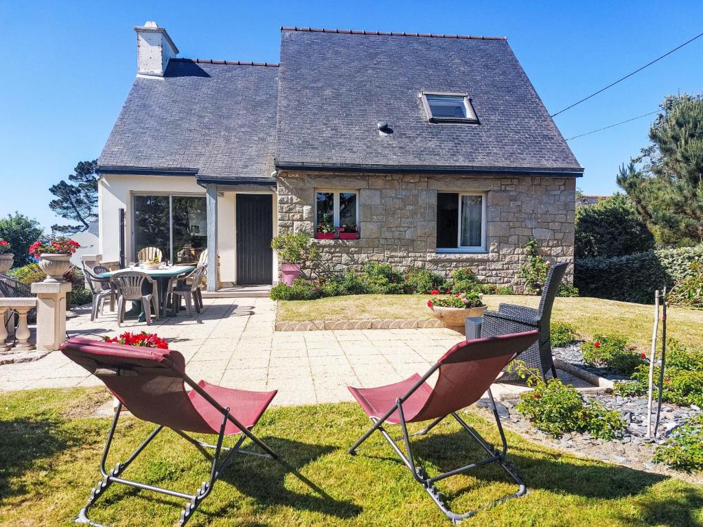 une maison avec deux chaises dans la cour dans l'établissement Holiday Home Les Courlis by Interhome, à Boudilleau