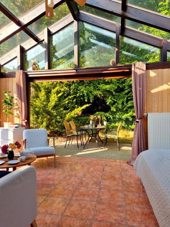 einen Wintergarten mit einem Zimmer mit Tisch und Stühlen in der Unterkunft Cosy Cottage in Braunfels