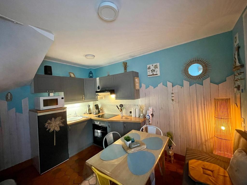 a kitchen with a table and a kitchen with blue walls at Côte & Mer in Fécamp
