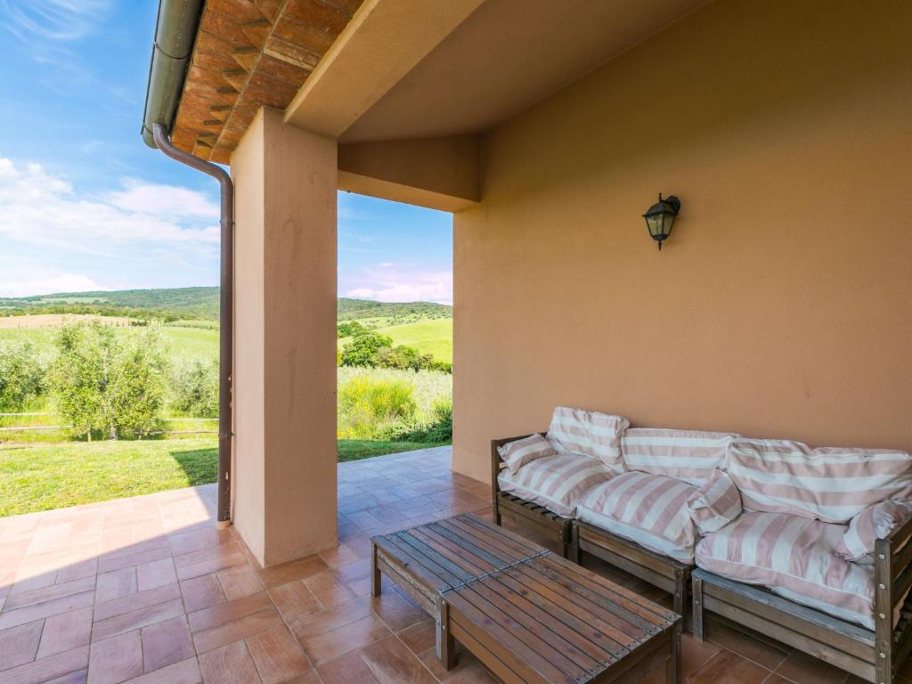 patio z kanapami i stołem oraz widokiem w obiekcie Holiday Home Il Fienile by Interhome w mieście Bibbona