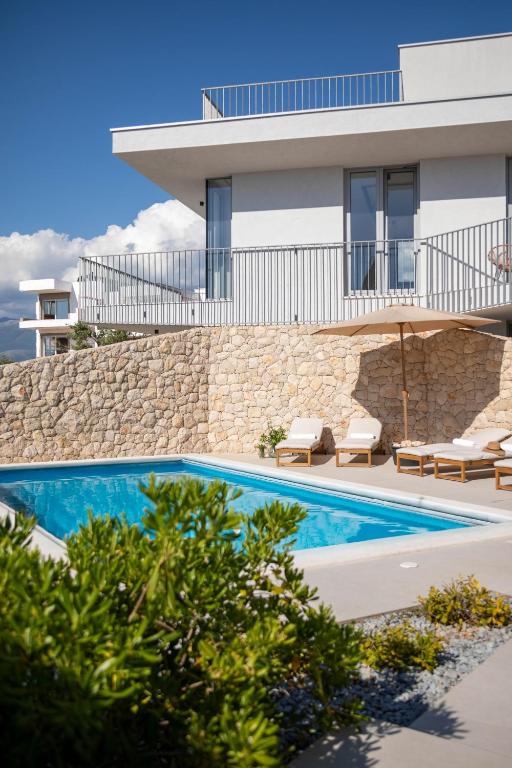a villa with a swimming pool and a building at Poolside Architect Studios in Novalja