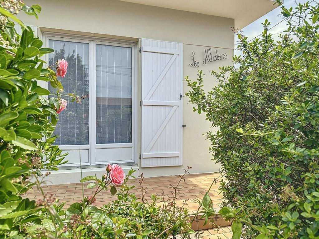 ein rosa Vogel, der vor einer Tür sitzt in der Unterkunft Holiday Home Les Albatros by Interhome in Pornic