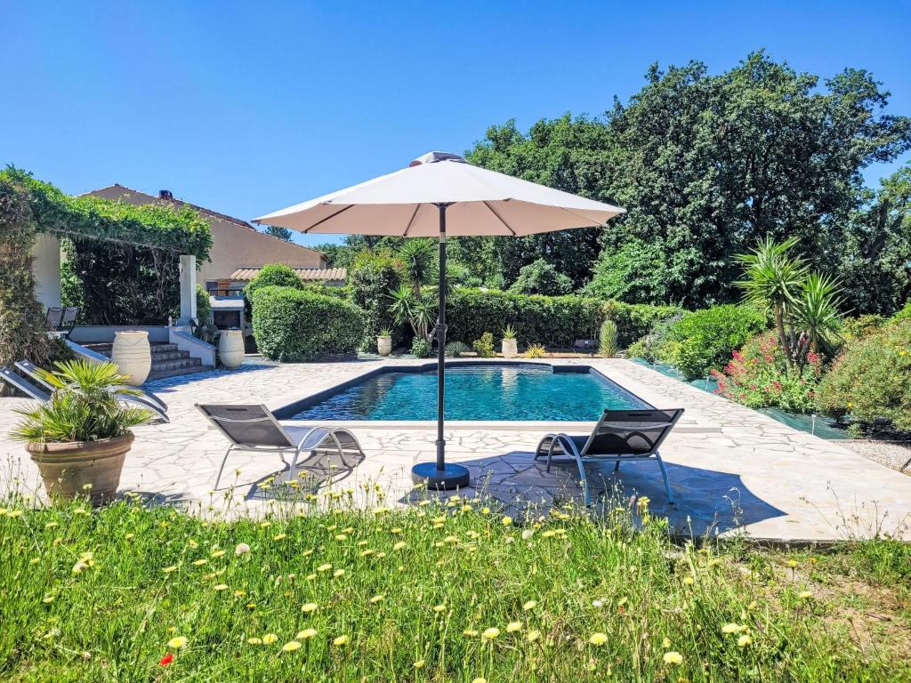 - Piscina con 2 sillas y sombrilla en Villa Aurval by Interhome, en Cogolin