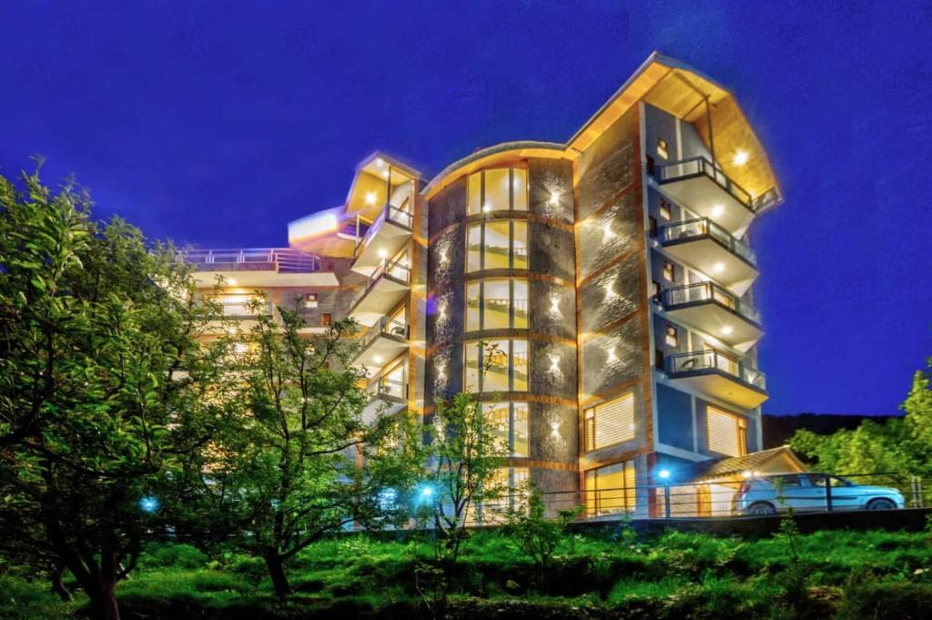 ein großes Gebäude mit Lichtern in der Nacht in der Unterkunft MRPS Eco Eden Resort nd Spa manali in Manali