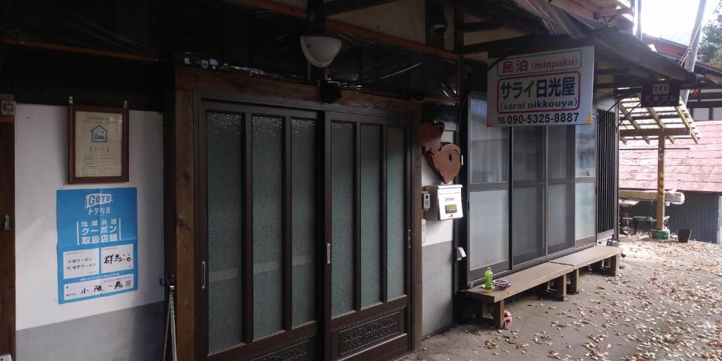 a building with signs on the side of it at Minpaku Sarai Nikkoya in Okkia