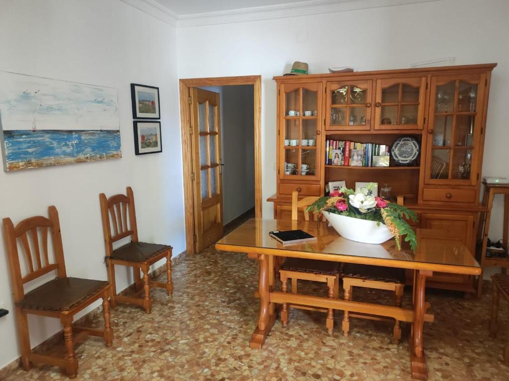 a dining room with a wooden table and chairs at chalet Mazagón in Moguer