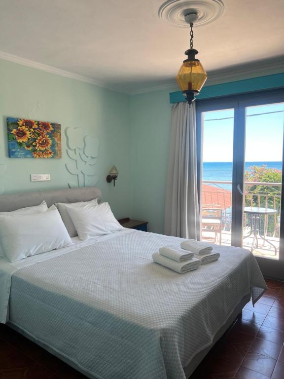 a bedroom with a bed with a view of the ocean at Medusa Apartments in Katelios