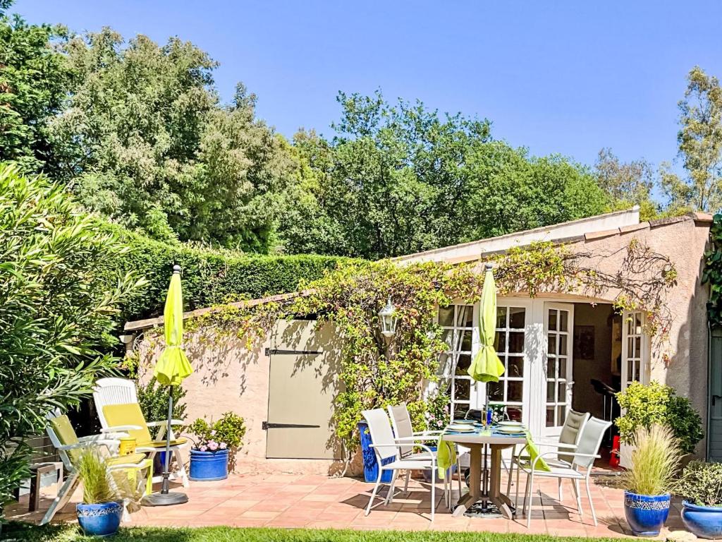 un patio con sedie e tavolo di fronte a una casa di Holiday Home Le Mimosa St Laurent by Interhome a Gassin
