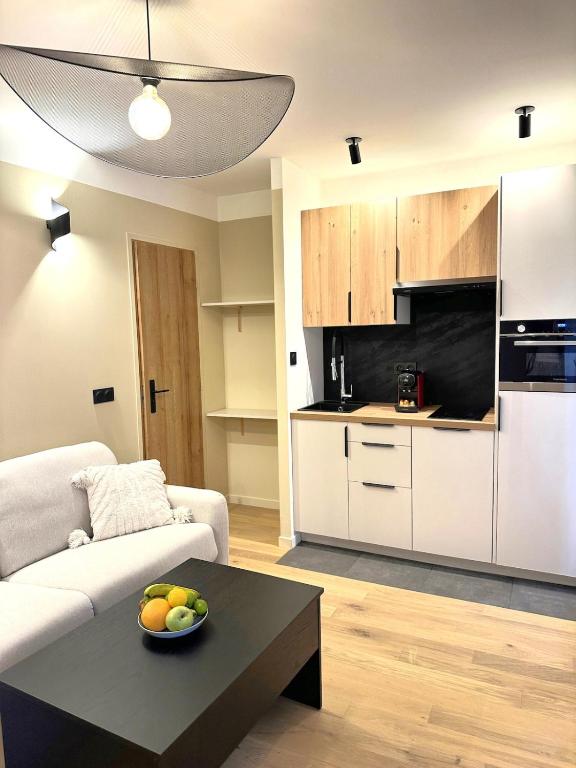 un salon avec un canapé et une table avec un bol de fruits dans l'établissement Studio Californien à deux pas de la plage, à Nice