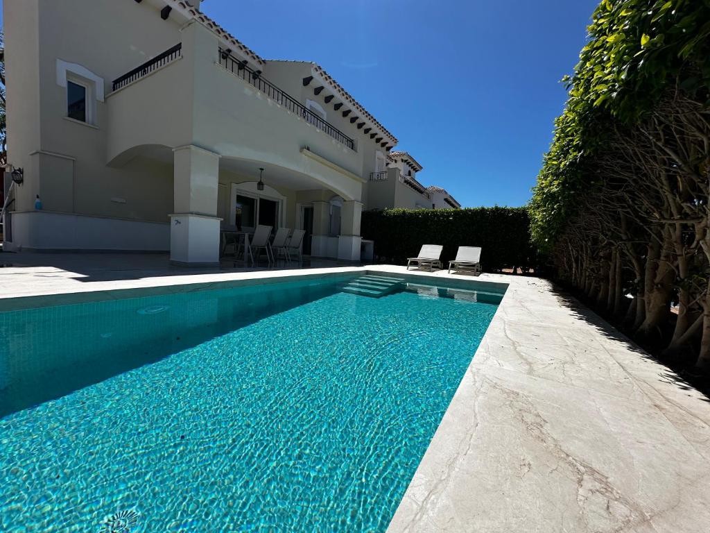a swimming pool in front of a house at Luxery home with private heated pool in Torre-Pacheco
