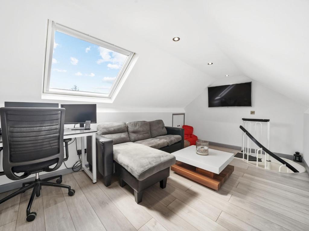 a living room with a couch and a desk at Pass the Keys Spacious Garden Family House - Marks Gate in Romford
