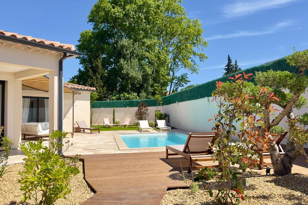 une cour arrière avec une piscine et une maison dans l'établissement La villa des Gypières, à LʼIsle-sur-la-Sorgue