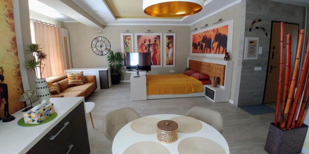 a living room with a bed and a table in a room at MIRA RESIDENCE Apart & Penthouse in Mamaia Nord