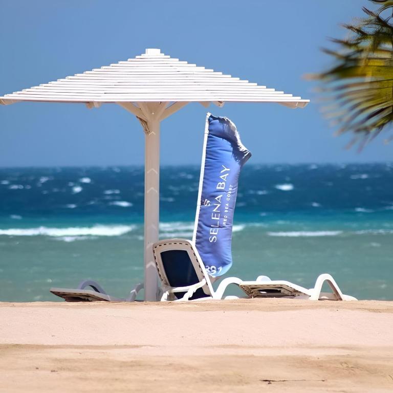 a chair and an umbrella on the beach at Selena Bay Hotel Suites in Hurghada