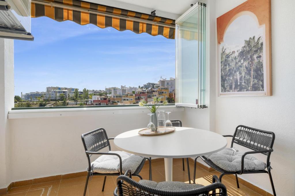 una sala da pranzo con tavolo e sedie e una grande finestra di Carvajal Beach Holiday Apartment a Benalmádena