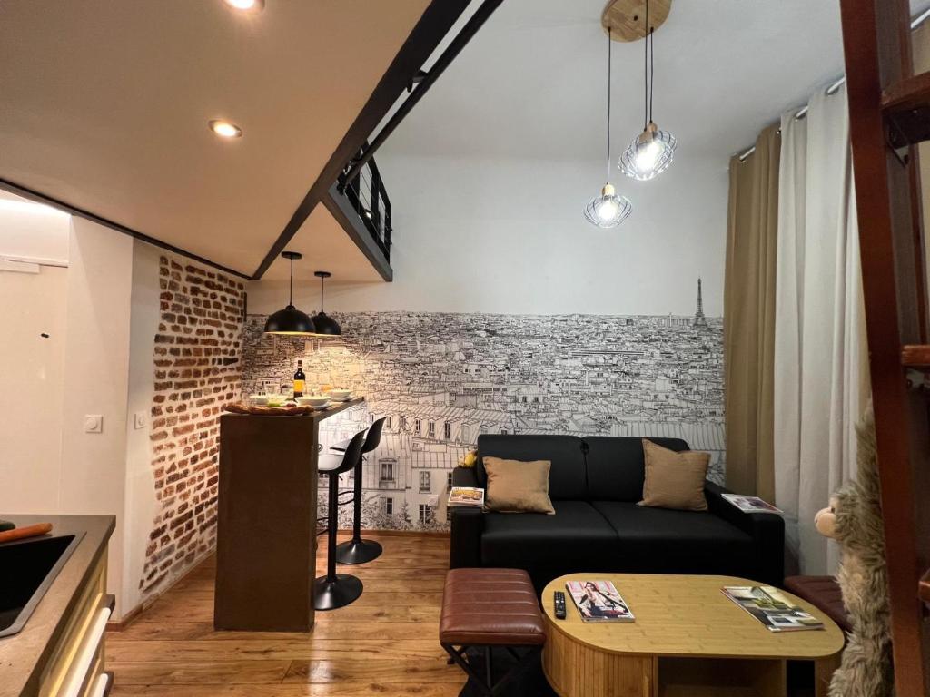 - un salon avec un canapé noir et un mur en briques dans l'établissement Appartement 2 pièces Rue de la voûte - Bail mobilité, à Paris