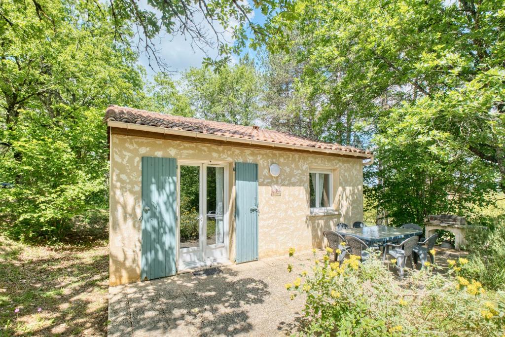 Cette petite maison en pierre dispose d'une table et d'une terrasse. dans l'établissement Gite Morille, à Salignac Eyvigues