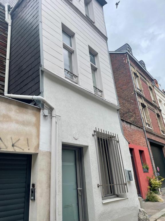une maison blanche avec une porte bleue dans une rue dans l'établissement Maison hypercentre Rouen avec parking, à Rouen