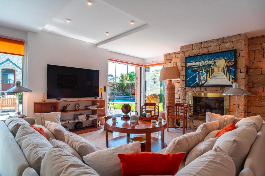 a living room with a couch and a fireplace at L'Oasis Bretonne - Charmante maison avec piscine in La Trinité-sur-Mer