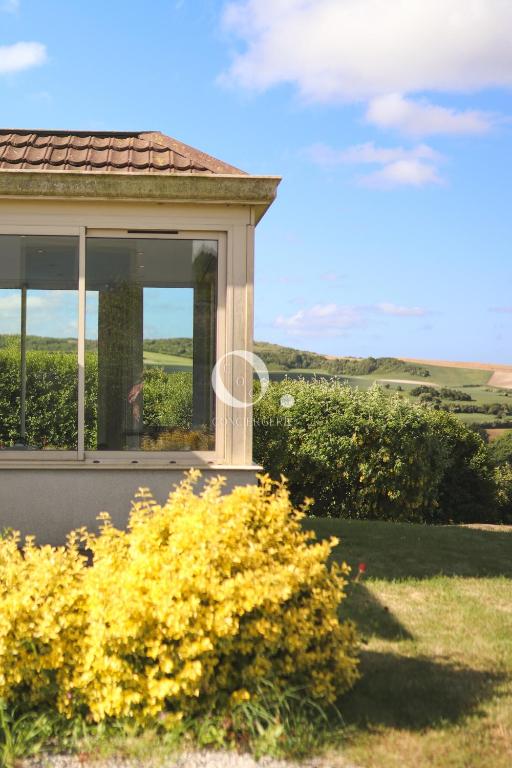 une maison avec une fenêtre et des fleurs jaunes dans l'établissement COC - Villa L'Idéal, à Hervelinghen