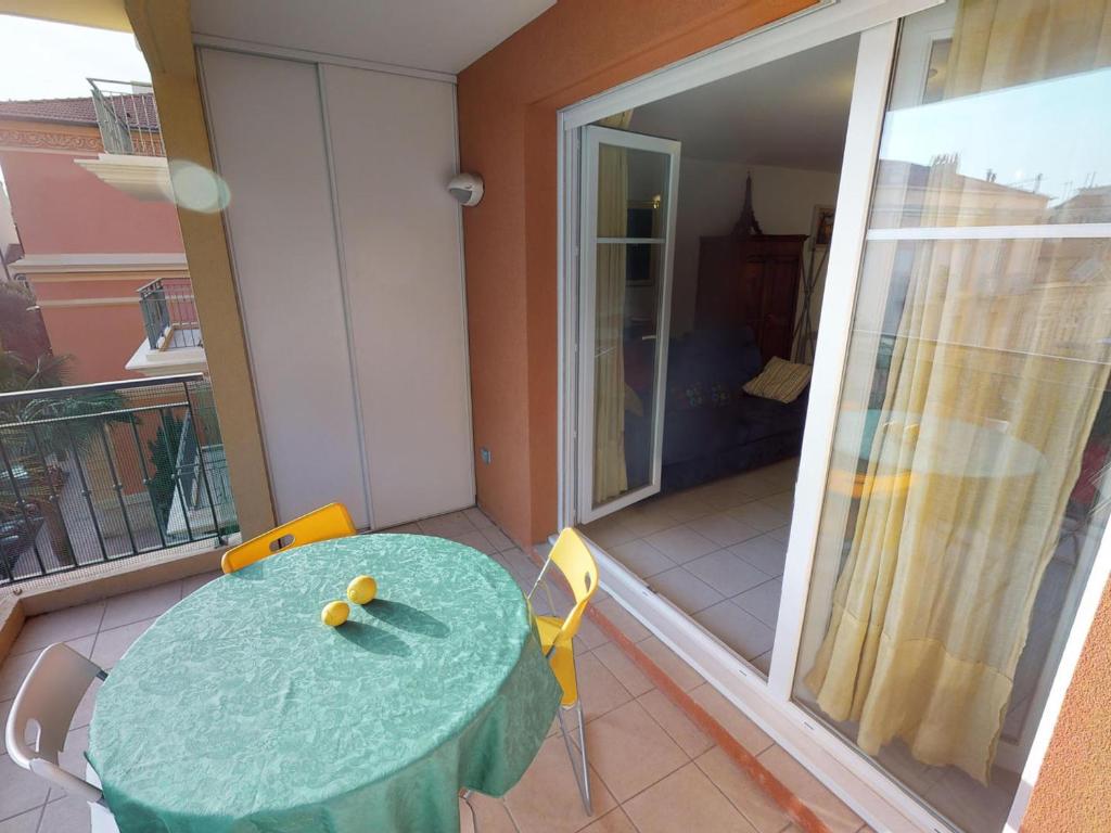 une pièce avec une table et des chaises sur un balcon dans l'établissement Spacieux 3P en Centre-ville de Menton, Terrasse, Parking, Wifi Gratuit, Proche Plage - FR-1-196-270, à Menton