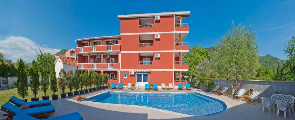 un edificio con piscina frente a un edificio en Apartments Gold, en Budva