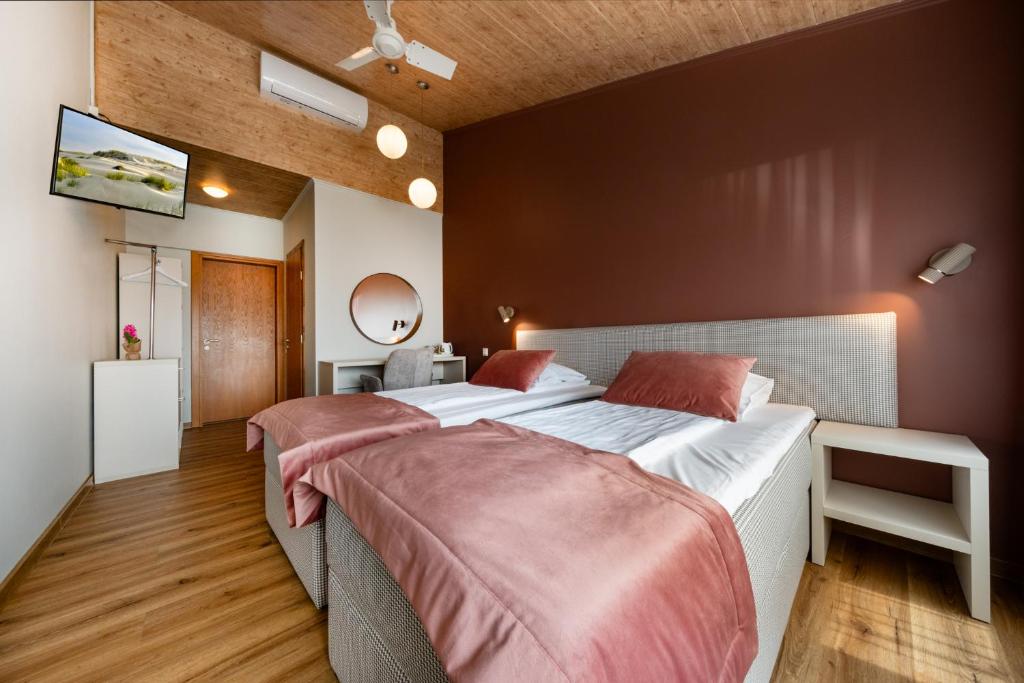 クライペダにあるAismaresのベッド2台と薄型テレビ付きのベッドルーム